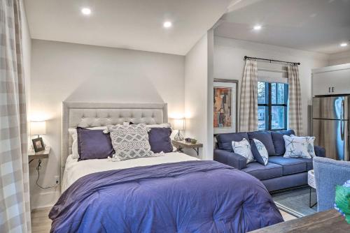 een slaapkamer met een bed en een blauwe bank bij Airy Bentonville Studio Less Than 1 Mile to City Square! in Bentonville