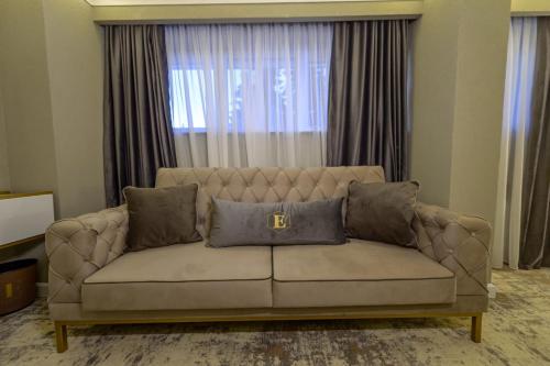 a couch in a living room with a large window at Elexus Predeal in Predeal