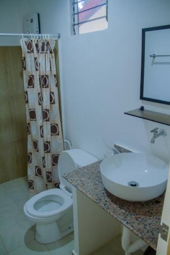 a bathroom with a white toilet and a sink at La Playa Estrella Beach Resort in Bantayan Island