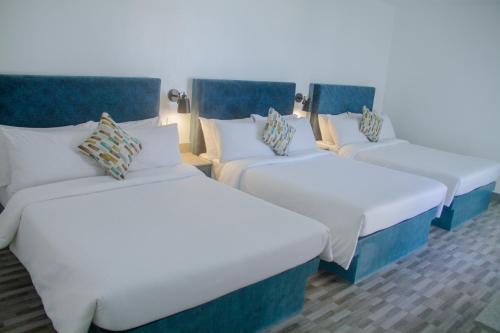 a row of three beds in a room at La Playa Estrella Beach Resort in Bantayan Island