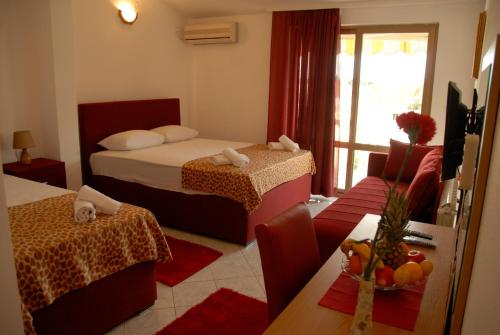 a bedroom with two beds and a living room at Guest House Pasha in Ulcinj