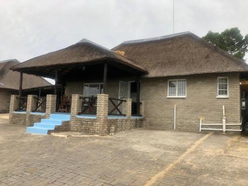 a house with a thatched roof and blue steps at Best view family loft in Oranjeville