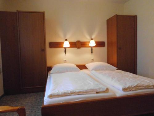 2 camas en un dormitorio con 2 luces en la pared en Land gut Hotel Dierks en Repke