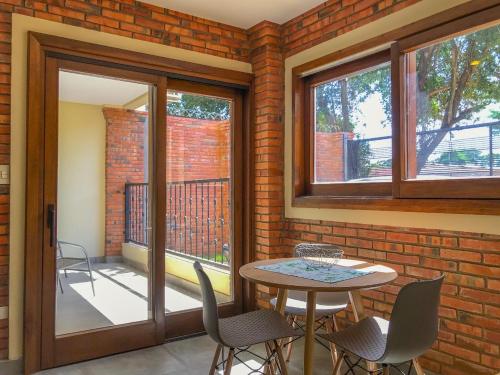 a patio with a table and chairs and windows at Aparthotel Los Laureles in San Lorenzo de la Frontera