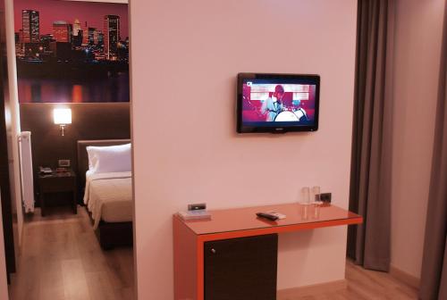 a hotel room with a television on a wall at Athens City Hotel in Athens