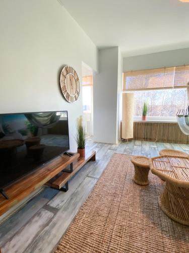 sala de estar con TV de pantalla plana grande en Happyhosts Beach House studio, en Hanko