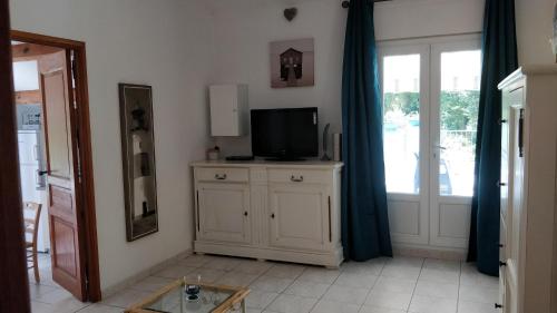ein Wohnzimmer mit einem TV auf einem Schrank und einer Tür in der Unterkunft Casetta in Ortiporio