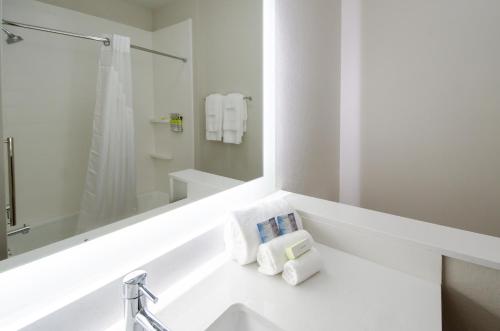 y baño con lavabo, espejo y toallas. en Holiday Inn Express & Suites Taylor, an IHG Hotel, en Taylor