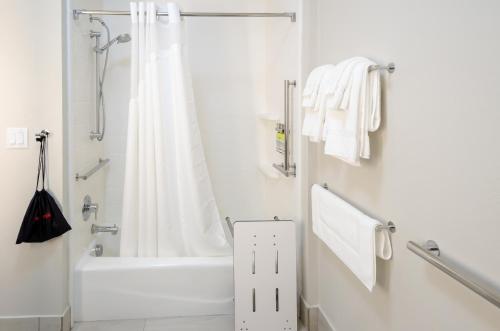 a white bathroom with a shower and a bath tub at Holiday Inn Express & Suites Taylor by IHG in Taylor