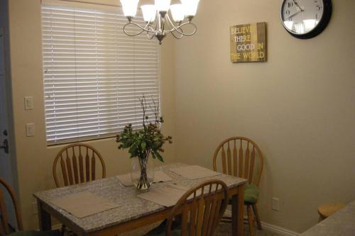 a dining room table with chairs and a clock on the wall at Mesquite Nevada Vacation Rental - Ground Level and double car garage in Mesquite