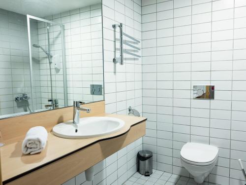 a bathroom with a sink and a toilet at Zaliasis slenis - Self check-in hotel - Free parking in Klaipėda