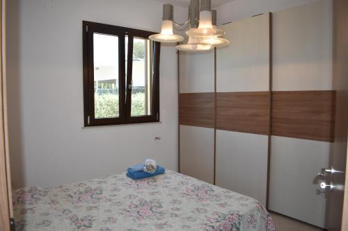 Un dormitorio con una cama y un espejo y una ventana. en In Riva al Mare da Franca, en Trabia