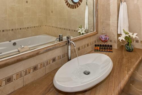 a bathroom with a sink and a tub at Cretan Blu Platanias in Plataniás