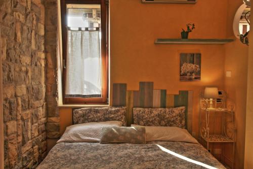 a bedroom with a bed with a window and a bedspread at Appartamento di Charme Suite Sole in Lazise