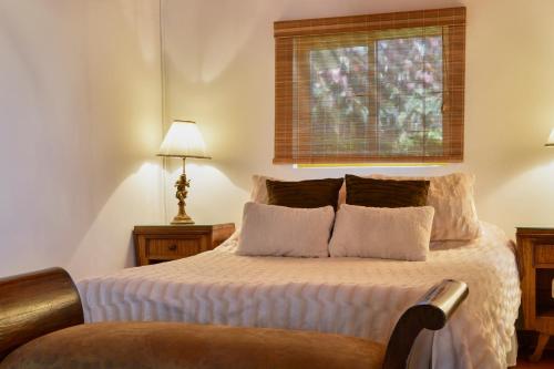 a bedroom with a bed with white sheets and a window at Finca Hotel Los Girasoles in Montenegro