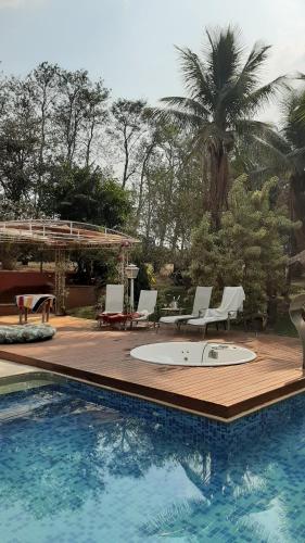 a pool with chairs and a table and a palm tree at Fazenda Santa Clementina in Araras