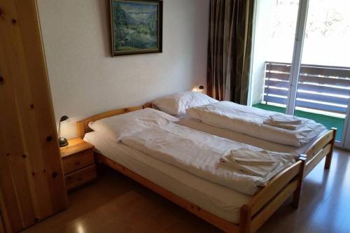 een slaapkamer met 2 bedden in een kamer met een raam bij Catherina 42 in Leukerbad