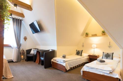 um quarto de hotel com duas camas e um sofá em Willa Joanna em Zakopane