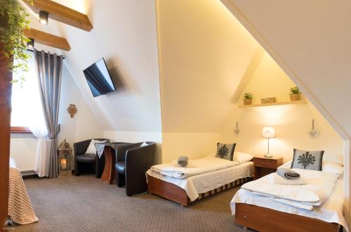 a hotel room with two beds and a couch at Willa Joanna in Zakopane