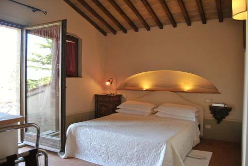 Un dormitorio con una cama y una ventana grande. en Villa La Valiana - Full Estate in Montepulciano - HEATED POOL, en Valiano