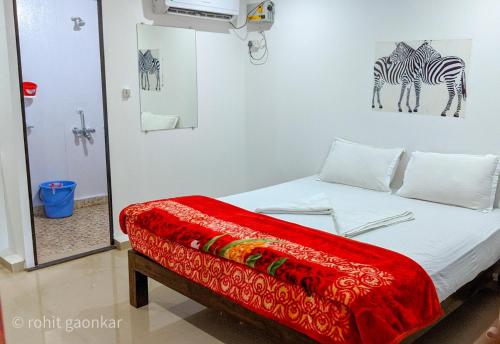 a bedroom with a bed with two zebras on the wall at Orange Sky Inn in Canacona