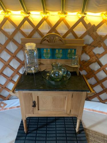a small wooden table with a plate and glasses on it at Valhalla Yurts Odin in Selfoss