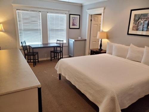 a bedroom with a bed and a table and chairs at Coronado Inn in San Diego