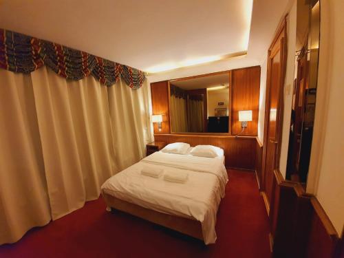 a hotel room with a bed and a large window at Rembrandtplein Hotel in Amsterdam