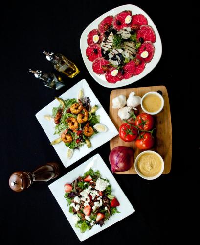 three plates of food on a table with plates of food at Best Western Premier Freeport Inn Calgary Airport in Calgary