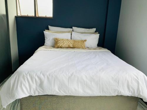 德班的住宿－Musgrave Seafern，一张带两个金色枕头的大白色床