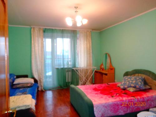 トムスクにある2-комнатная в Центре Томскаの緑のベッドルーム(ベッド1台、窓付)