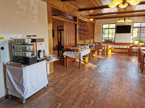 um restaurante com pisos e mesas e cadeiras de madeira em Chata u Tří Sluk em Modrava