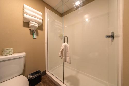 a bathroom with a shower and a toilet and towels at Cobblestone Inn & Suites - Trenton in Trenton