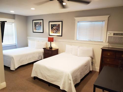 a bedroom with two beds and two windows at Coronado Island Inn in San Diego