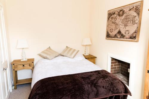 1 dormitorio con 1 cama y chimenea en Stylish 2 bedroom, city centre apartment, en Aberdeen