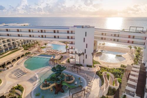 an aerial view of a hotel with a pool and the ocean at Sensira Resort & Spa Riviera Maya All Inclusive in Puerto Morelos