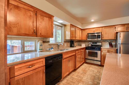 a kitchen with wooden cabinets and stainless steel appliances at 99 Yosemite Mountain Lodge in Wawona