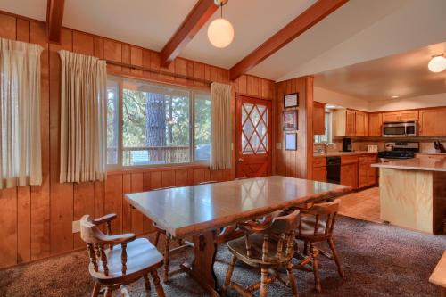 een keuken met een grote houten tafel en stoelen bij 99 Yosemite Mountain Lodge in Wawona