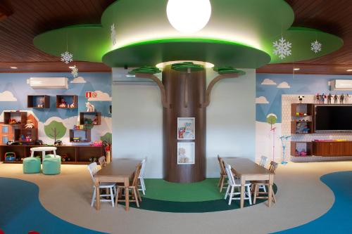 a room with tables and chairs in a play room at Exclusive Gramado Hotel & Spa by Gramado Parks in Gramado