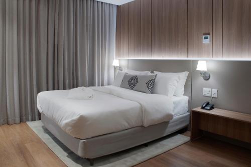 a large white bed in a hotel room at Exclusive Gramado Hotel & Spa by Gramado Parks in Gramado