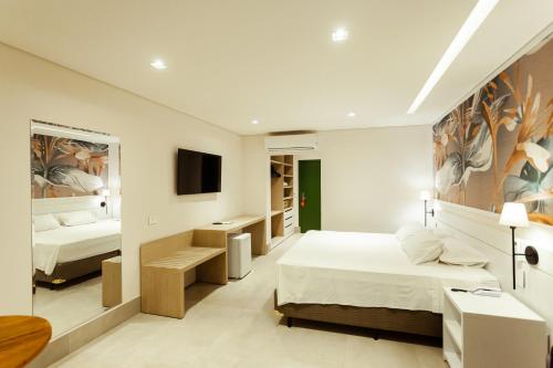 a hotel room with two beds and a tv at Vistabela Resort & Spa in São Sebastião