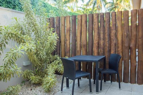 a black table and chairs in front of a fence at Vistabela Resort & Spa in São Sebastião