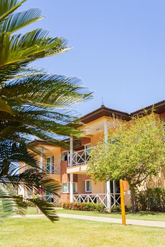 a large yellow building with a tree in front of it at Vistabela Resort & Spa in São Sebastião