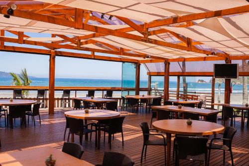 a restaurant with tables and chairs and a view of the ocean at Vistabela Resort & Spa in São Sebastião