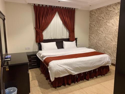 1 dormitorio con 1 cama grande y ventana en تيان, en Riad