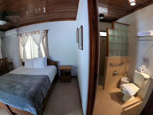 a small bedroom with a bed and a shower at Casa Cecilia Beach Front in Santa Teresa Beach