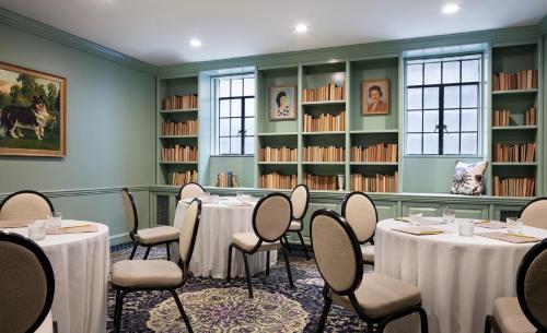 a room with tables and chairs and books at Graduate Evanston in Evanston