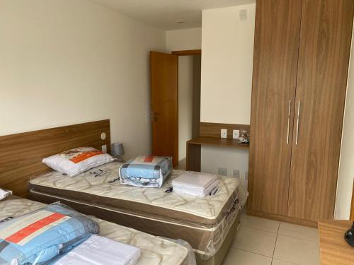 a room with two beds and a wooden cabinet at Apart Hotel Diamond Flat 2 Quartos in Nova Iguaçu