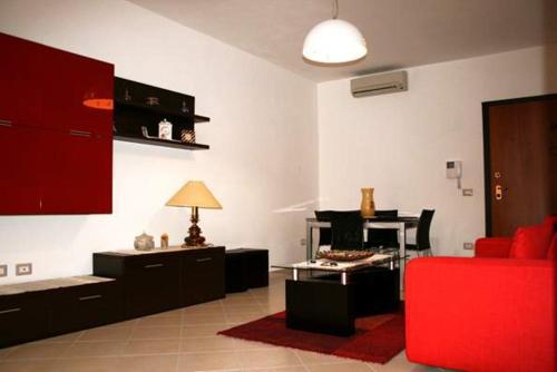 ein Wohnzimmer mit einem roten Sofa und einem Klavier in der Unterkunft Piccolo B in Bosa