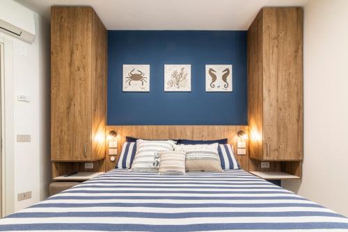 Schlafzimmer mit einem Bett mit blauer Wand in der Unterkunft CATTOLICA 4 FAMILY Folonari 12 in Cattolica